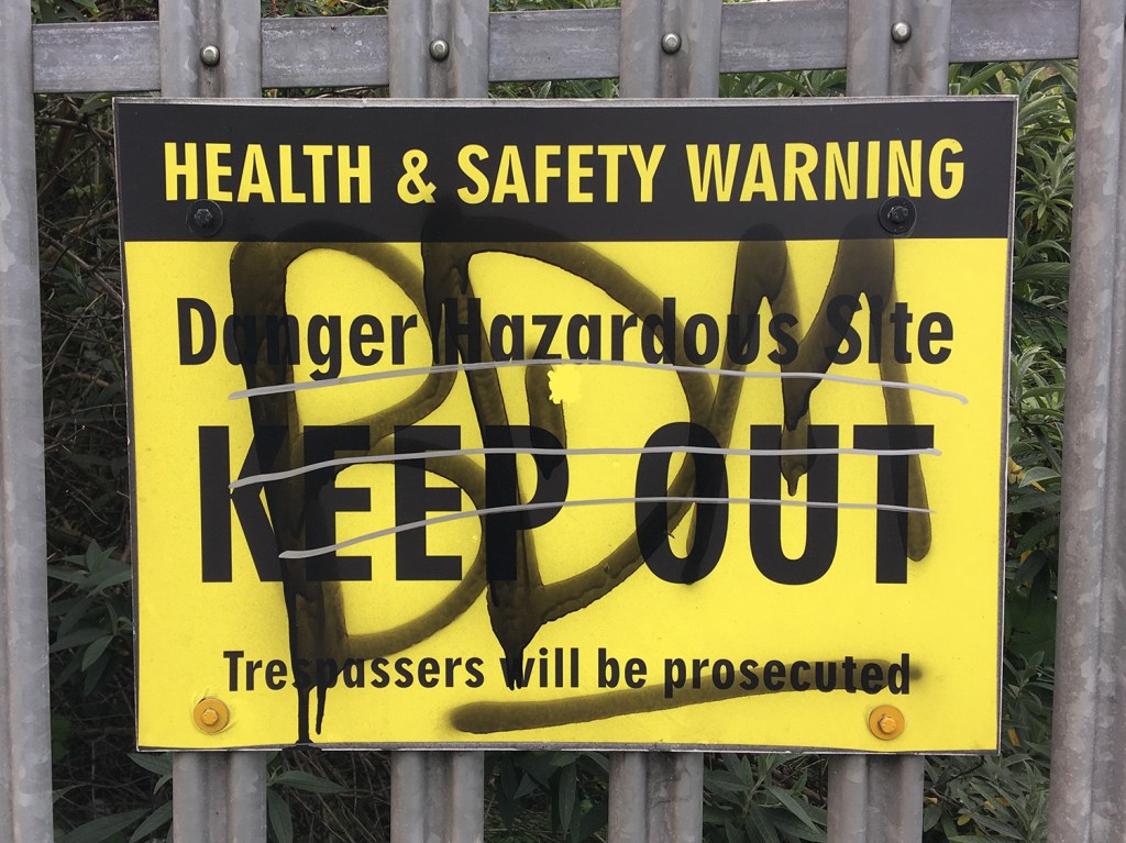 A sign saying 'Danger Hazardous Site KEEP OUT'