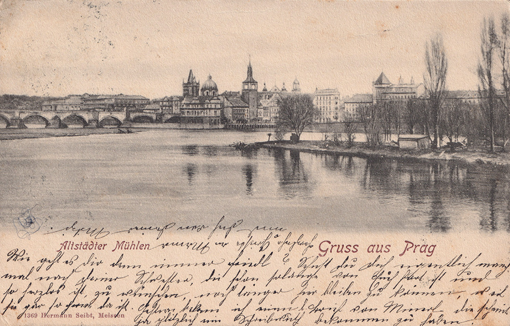 A sepia-photograph of the river and old mills in Prague.